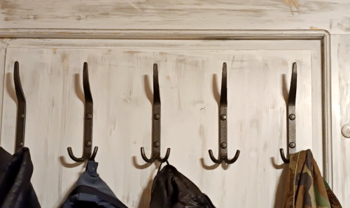 Kované věšáky na oblečení na desce