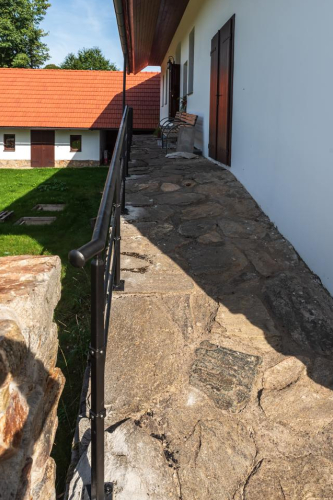 Kované zábradlí na náspí z kamenů