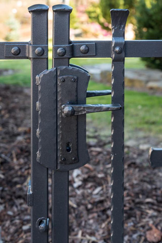zámek kované bránky nýtovaného plotu